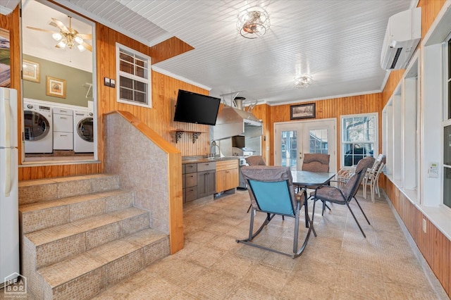 dining room with washer and dryer, wooden walls, an AC wall unit, and a ceiling fan
