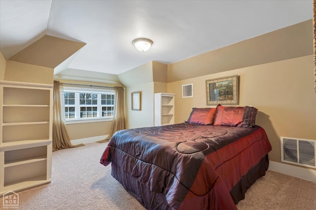 carpeted bedroom featuring baseboards, lofted ceiling, and visible vents