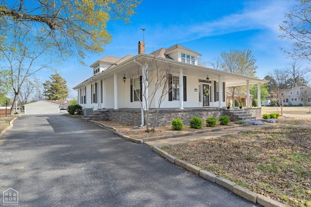 view of property exterior featuring a porch, a chimney, and central air condition unit