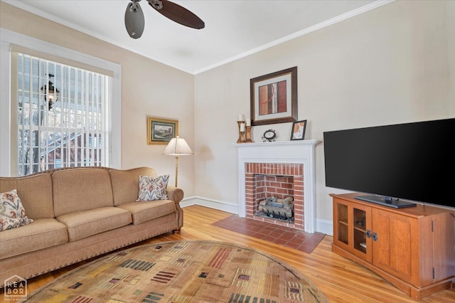 living area with crown molding, baseboards, a ceiling fan, and light wood-style floors