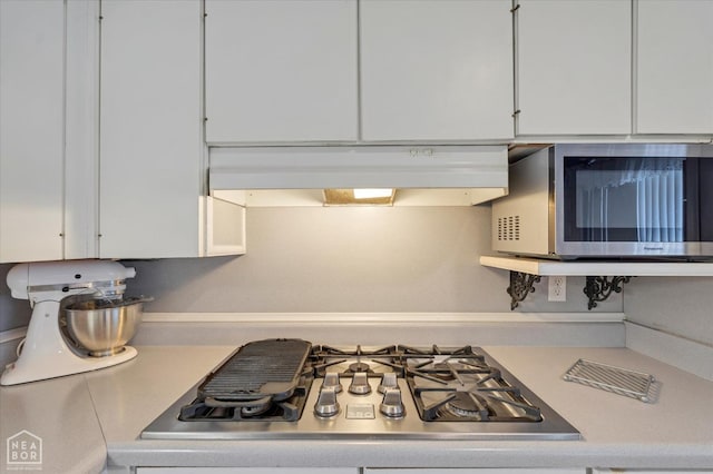kitchen featuring white cabinets, light countertops, stainless steel appliances, and under cabinet range hood