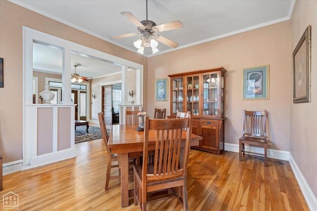 dining area with light wood finished floors, baseboards, a ceiling fan, and ornamental molding