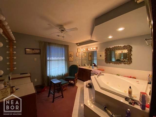 bathroom featuring a jetted tub, vanity, and a ceiling fan
