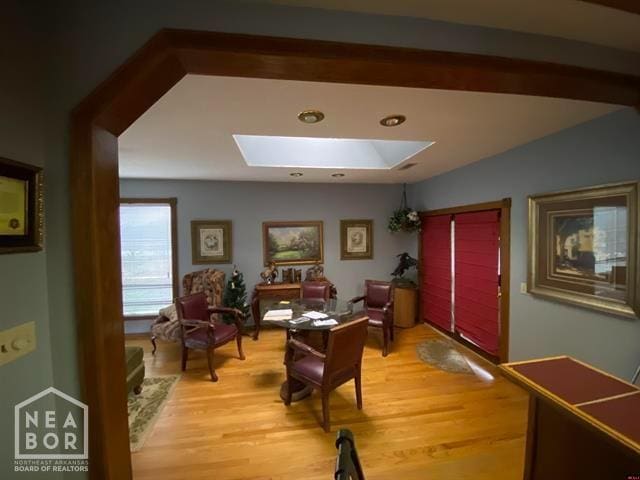 living area with a skylight and light wood-style floors