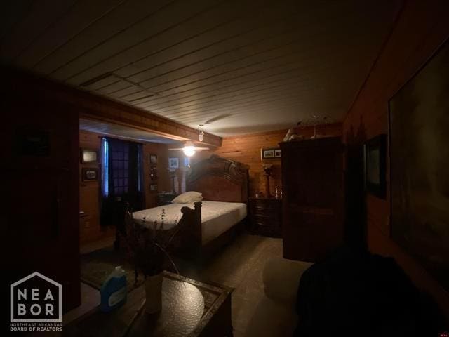 bedroom featuring wood walls, a ceiling fan, and wooden ceiling