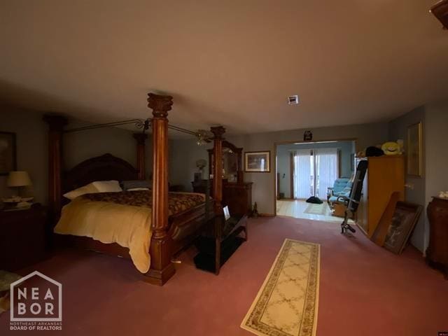 carpeted bedroom featuring visible vents