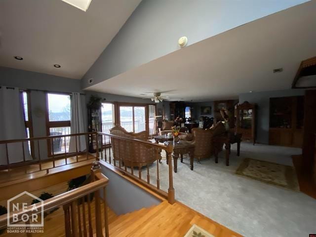 interior space featuring vaulted ceiling, a ceiling fan, and wood finished floors