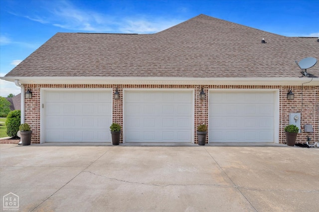 4260 Weldon Cv, Jonesboro, AR 72404 - view of side of property with roof with shingles, brick siding, driveway, and a garage