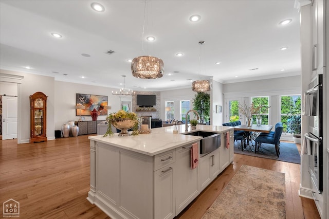 4260 Weldon Cv, Jonesboro, AR 72404 - kitchen featuring a sink, open floor plan, white cabinetry, an island with sink, and light stone countertops