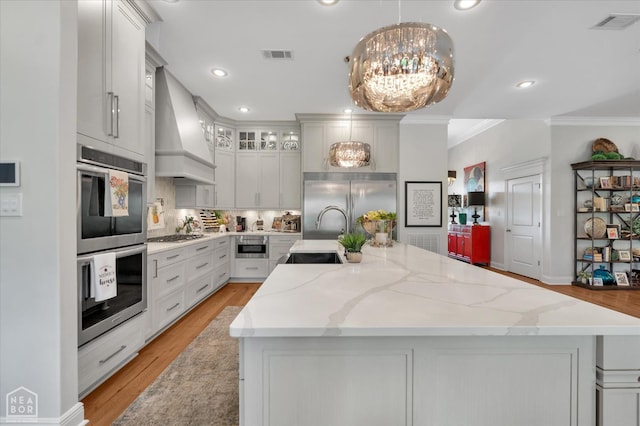 4260 Weldon Cv, Jonesboro, AR 72404 - kitchen featuring a sink, premium range hood, appliances with stainless steel finishes, crown molding, and a kitchen island with sink