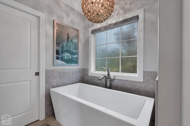4260 Weldon Cv, Jonesboro, AR 72404 - full bath with a soaking tub, tile walls, and a chandelier