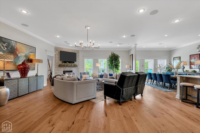 4260 Weldon Cv, Jonesboro, AR 72404 - living room featuring a chandelier, light wood-style floors, a stone fireplace, recessed lighting, and crown molding