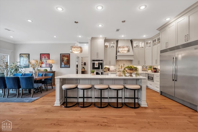 4260 Weldon Cv, Jonesboro, AR 72404 - kitchen featuring built in appliances, a breakfast bar, light countertops, custom range hood, and crown molding