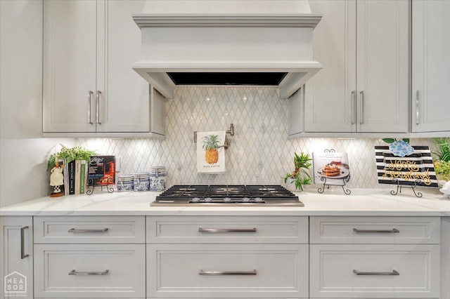 4260 Weldon Cv, Jonesboro, AR 72404 - kitchen featuring stainless steel gas cooktop, custom exhaust hood, tasteful backsplash, and white cabinetry