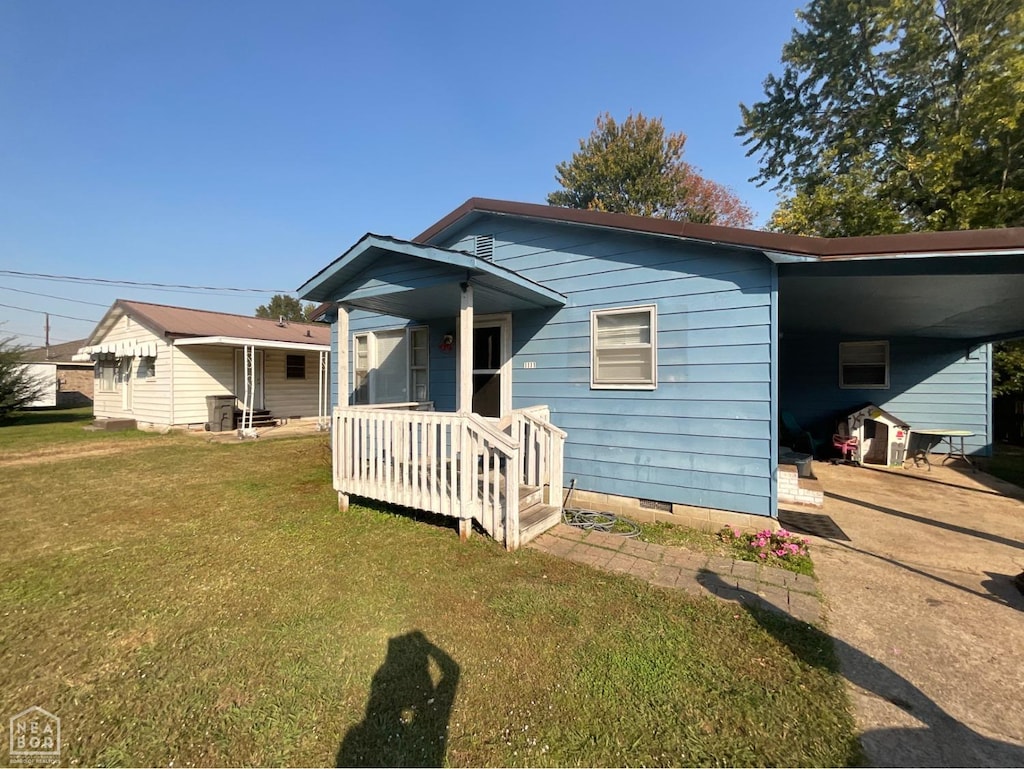 view of front of house featuring a carport, a front yard, crawl space, and concrete driveway