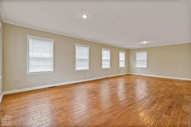 unfurnished room with light wood-style floors, a healthy amount of sunlight, and crown molding