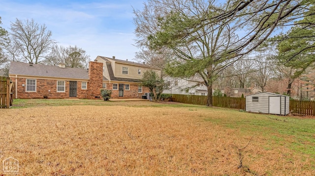 view of yard featuring a shed, a fenced backyard, and an outdoor structure