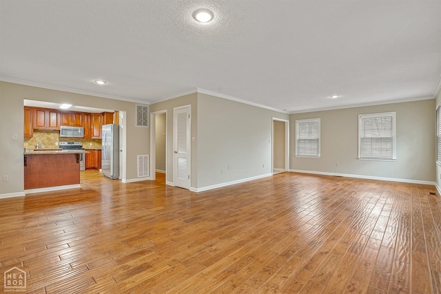 unfurnished living room with light wood-style floors, baseboards, ornamental molding, and visible vents