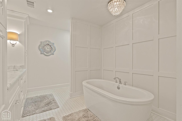 803 Fairway Dr, Jonesboro, AR 72401 - bathroom featuring a freestanding tub, vanity, tile patterned flooring, visible vents, and a decorative wall