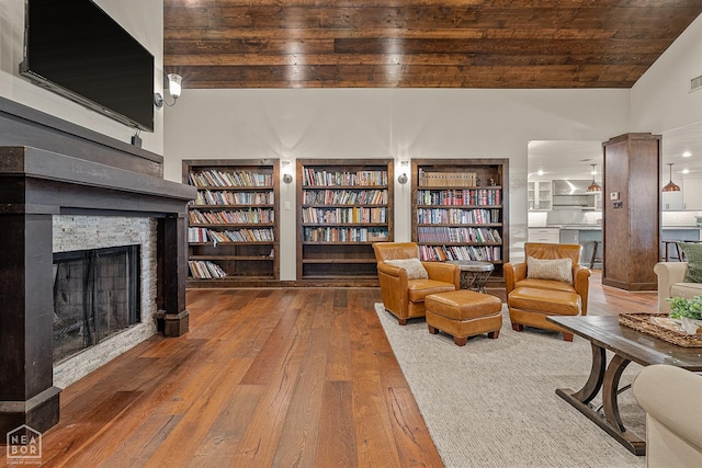 803 Fairway Dr, Jonesboro, AR 72401 - sitting room featuring built in features, a stone fireplace, wood ceiling, lofted ceiling, and wood-type flooring