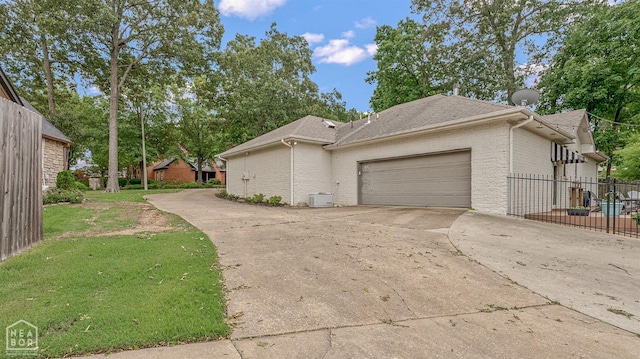 803 Fairway Dr, Jonesboro, AR 72401 - view of side of home featuring roof with shingles, fence, brick siding, an attached garage, and driveway