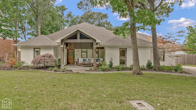 803 Fairway Dr, Jonesboro, AR 72401 - mid-century inspired home with brick siding, outdoor lounge area, fence, and a front lawn