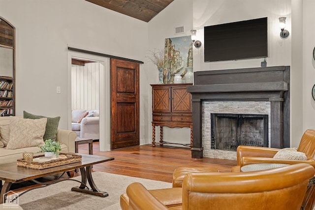 803 Fairway Dr, Jonesboro, AR 72401 - living area with a stone fireplace, visible vents, wooden ceiling, wood finished floors, and lofted ceiling