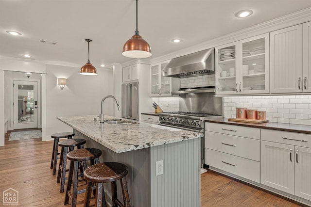803 Fairway Dr, Jonesboro, AR 72401 - kitchen with visible vents, wall chimney exhaust hood, a sink, high end appliances, and decorative backsplash
