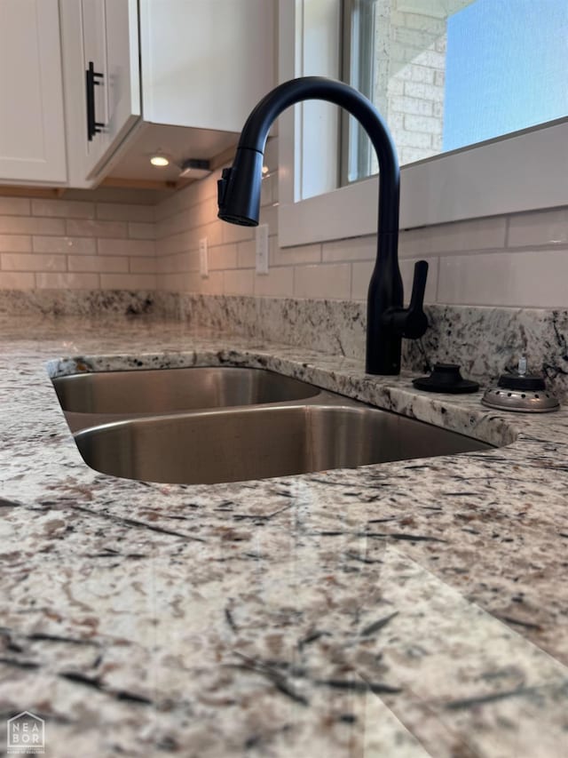 100 Lenford Dr, Bono, AR 72416 - kitchen view of a sink, white cabinetry, light stone countertops, and tasteful backsplash