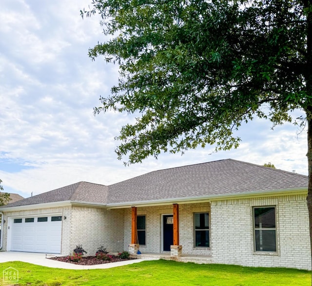 100 Lenford Dr, Bono, AR 72416 - ranch-style house featuring brick siding, a front lawn, a garage, concrete driveway, and roof with shingles