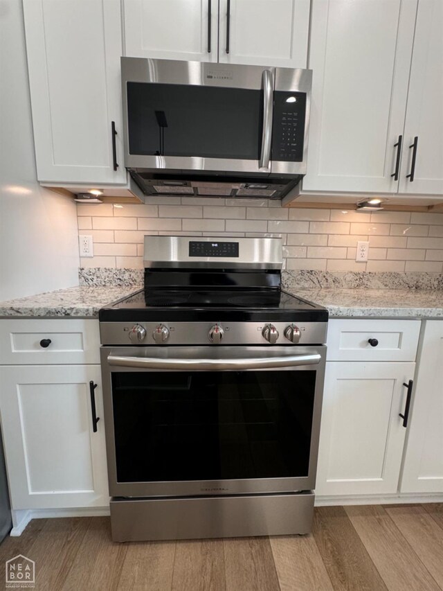 100 Lenford Dr, Bono, AR 72416 - kitchen featuring stainless steel appliances, light wood-type flooring, white cabinetry, and tasteful backsplash