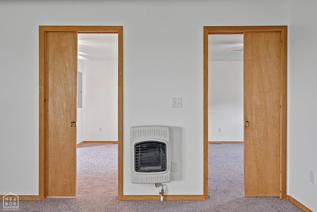 unfurnished living room with baseboards, heating unit, and carpet flooring