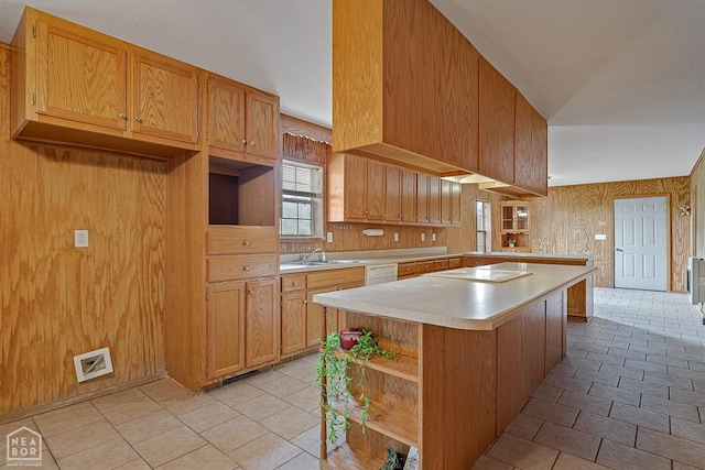 kitchen featuring open shelves, a sink, light countertops, a kitchen island, and a peninsula