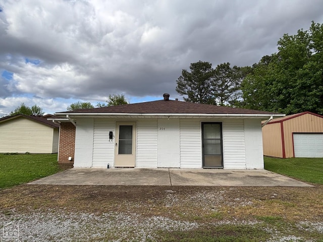 204 SE 4th St E, Walnut Ridge, AR 72476 - back of house featuring a patio area, an outbuilding, and a lawn