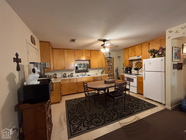 kitchen with white appliances, visible vents, under cabinet range hood, ceiling fan, and light countertops