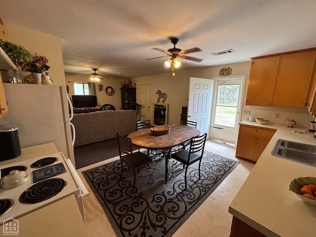 kitchen with white appliances, visible vents, ceiling fan, a sink, and light countertops