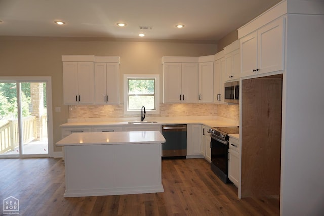 kitchen featuring stainless steel appliances, tasteful backsplash, a sink, and a kitchen island
