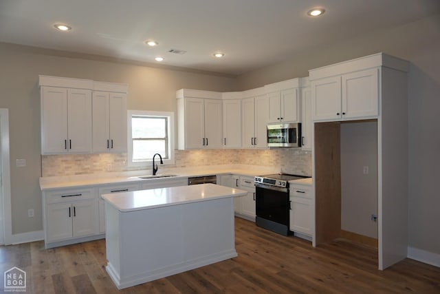 kitchen with a sink, visible vents, backsplash, appliances with stainless steel finishes, and a kitchen island