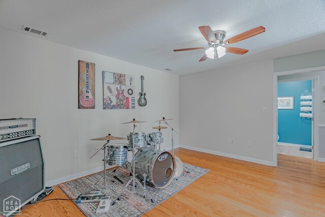 rec room with visible vents, baseboards, a ceiling fan, and wood finished floors