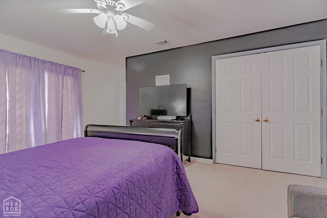 bedroom featuring visible vents, ceiling fan, a closet, and light carpet