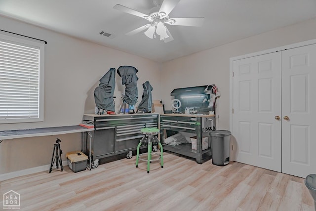 office space with wood finished floors, baseboards, a ceiling fan, and visible vents