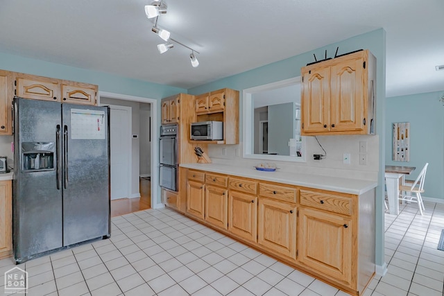 kitchen featuring light brown cabinets, light tile patterned floors, light countertops, backsplash, and black appliances