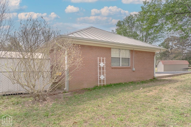 view of property exterior with a lawn, metal roof, a standing seam roof, and brick siding