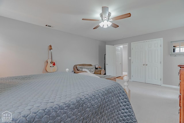 bedroom featuring visible vents, baseboards, a closet, ceiling fan, and light carpet