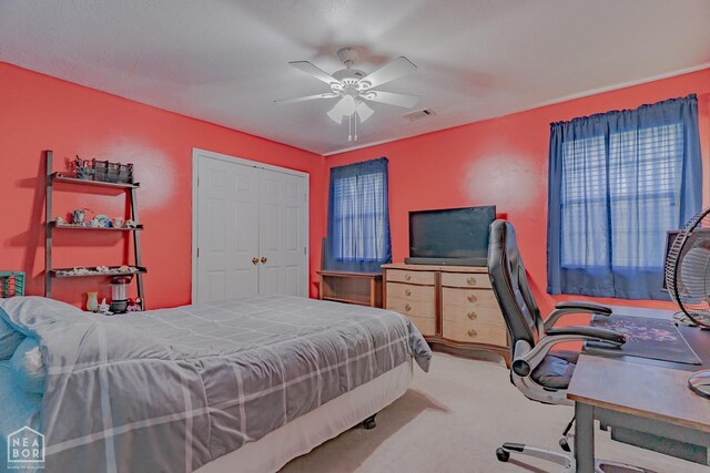 bedroom with a closet, carpet flooring, a ceiling fan, and visible vents