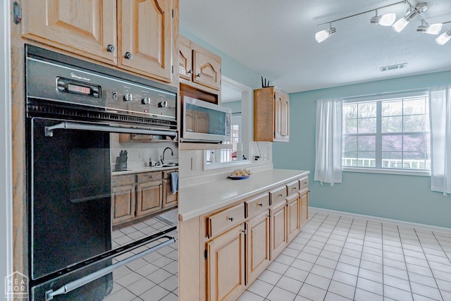 kitchen featuring stainless steel microwave, light tile patterned floors, visible vents, and light countertops