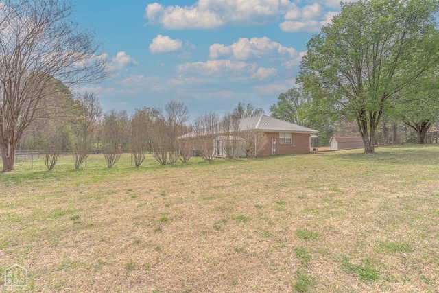 view of yard featuring fence, an outbuilding, and a detached garage