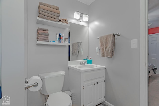 bathroom featuring vanity, baseboards, and toilet