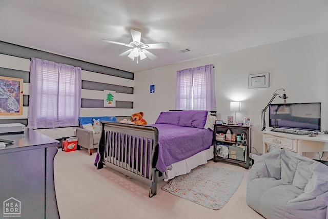 bedroom with visible vents, a ceiling fan, and light colored carpet
