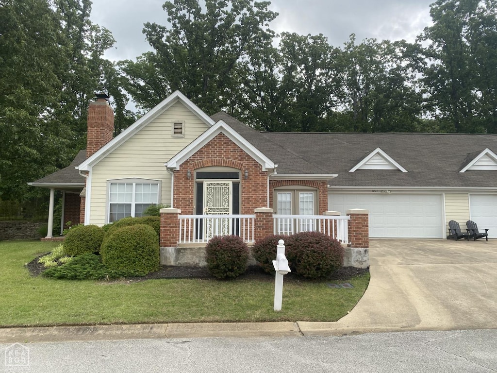 1811 Frank Hall Cir, Jonesboro, AR 72401 - view of front of home with brick siding, concrete driveway, a front lawn, and roof with shingles